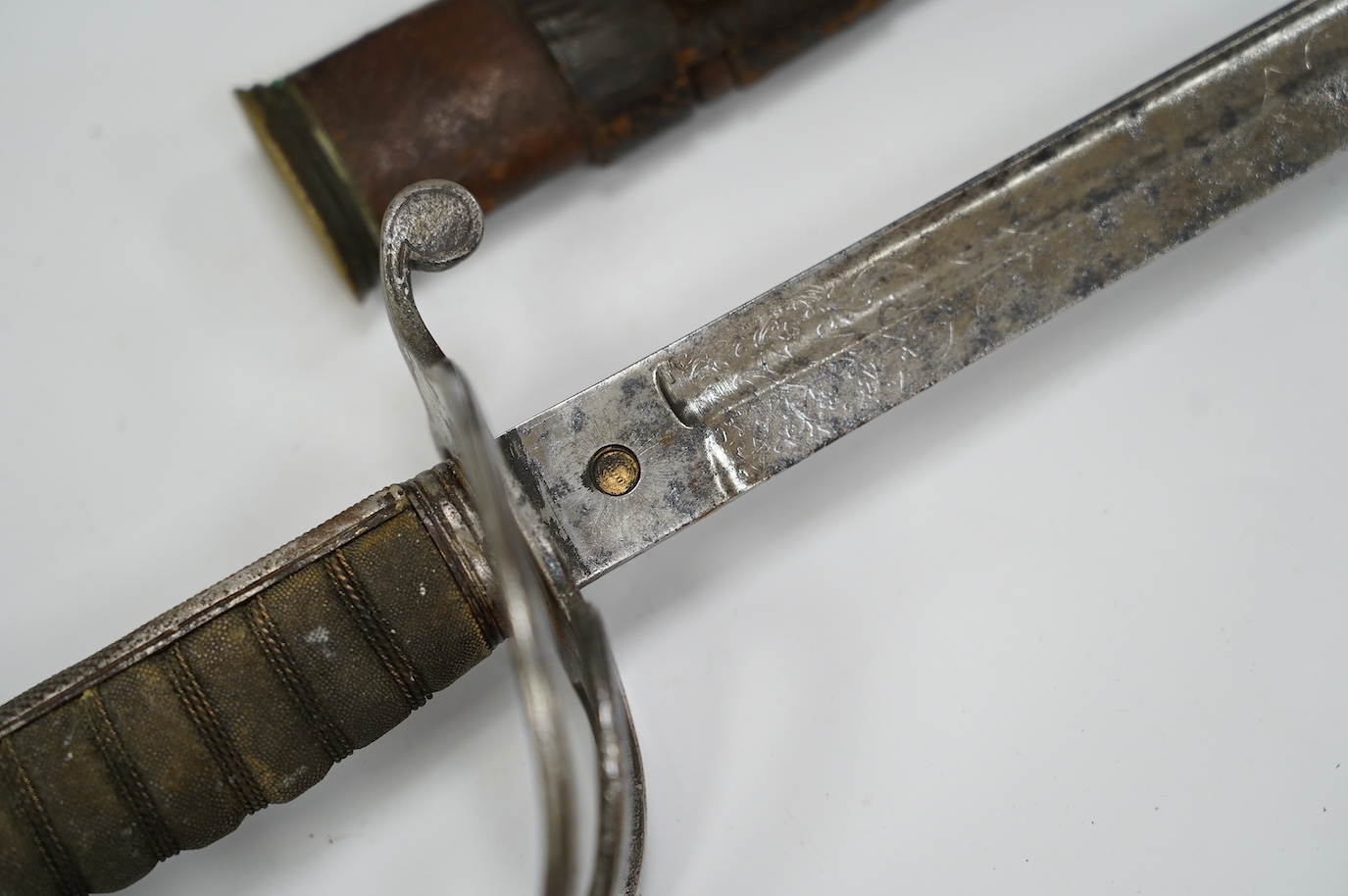 A George V Royal Artillery sword, regulation blade and hilt, in its leather scabbard, blade 90cm. Condition - poor, heavily pitted